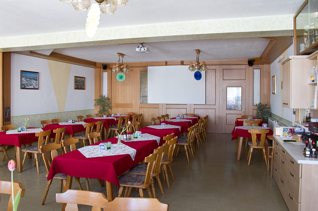 Festsaal mit gedeckten Tischen und Bühne